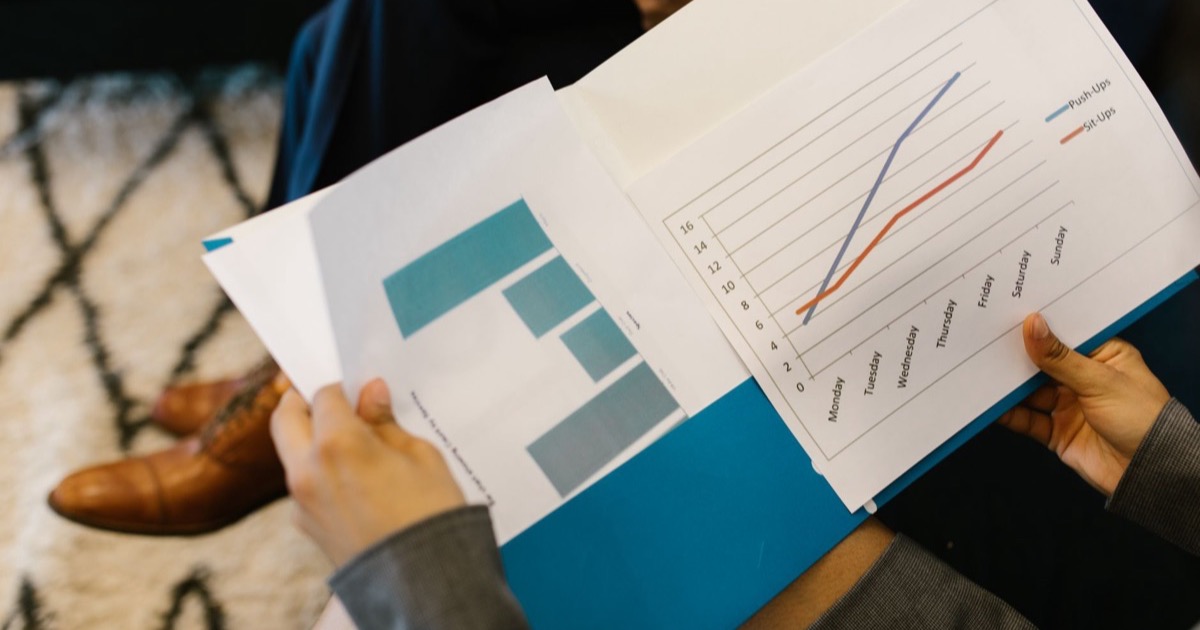 Material de apresentação com gráficos sendo consultado em reunião