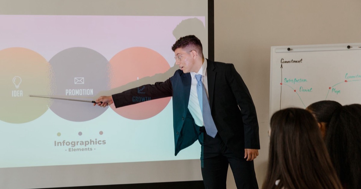 Profissional apresentando slides para um grupo em sala de reunião