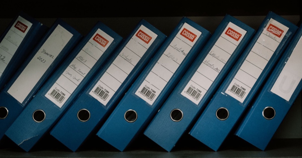 Pastas de documentação organizadas em prateleira de escritório