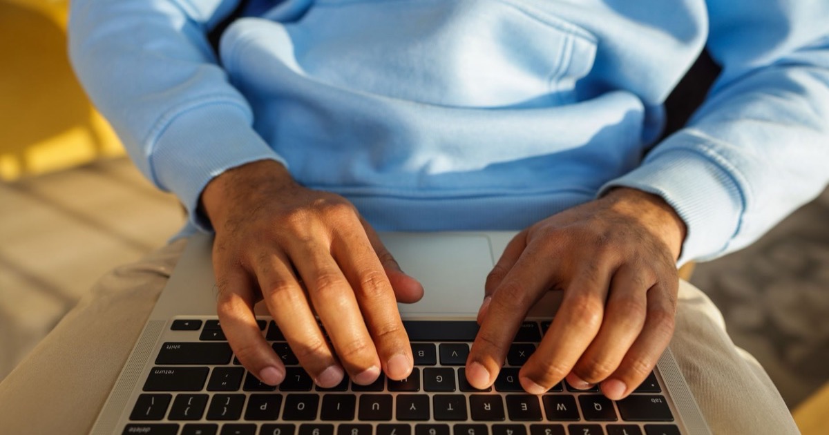 Mãos digitando e-mail de prospecção em teclado de notebook