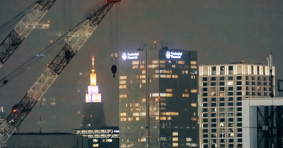Guindastes e obra industrial iluminados à noite ilustrando como conseguir clientes na engenharia