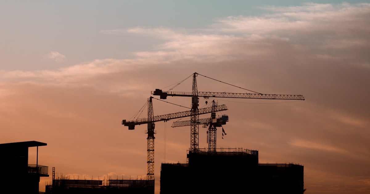 Guindastes de obra ao entardecer ilustrando o funil de vendas para engenharia B2B