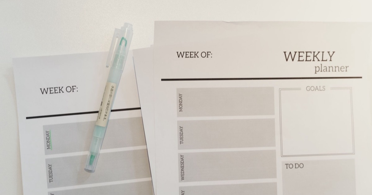 Planner semanal com blocos de agenda definidos sobre a mesa