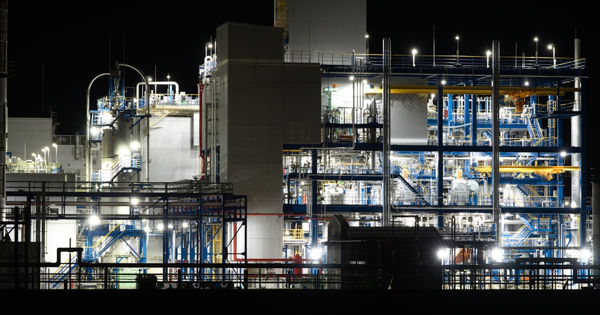 Planta industrial iluminada à noite ilustrando marketing para engenharia
