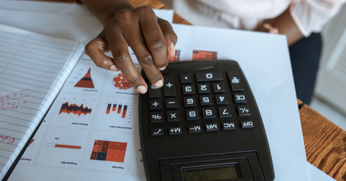 Cálculo de reajuste sendo conferido sobre relatórios financeiros