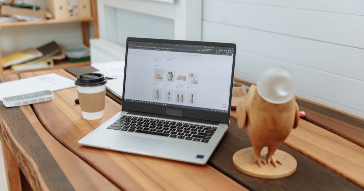 Notebook sobre mesa de escritório exibindo o site de uma empresa